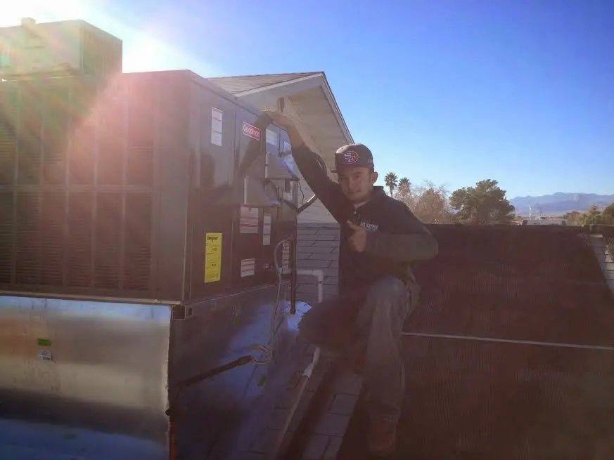 HVAC technician performing Boiler Repair on a rooftop unit in Goddard
